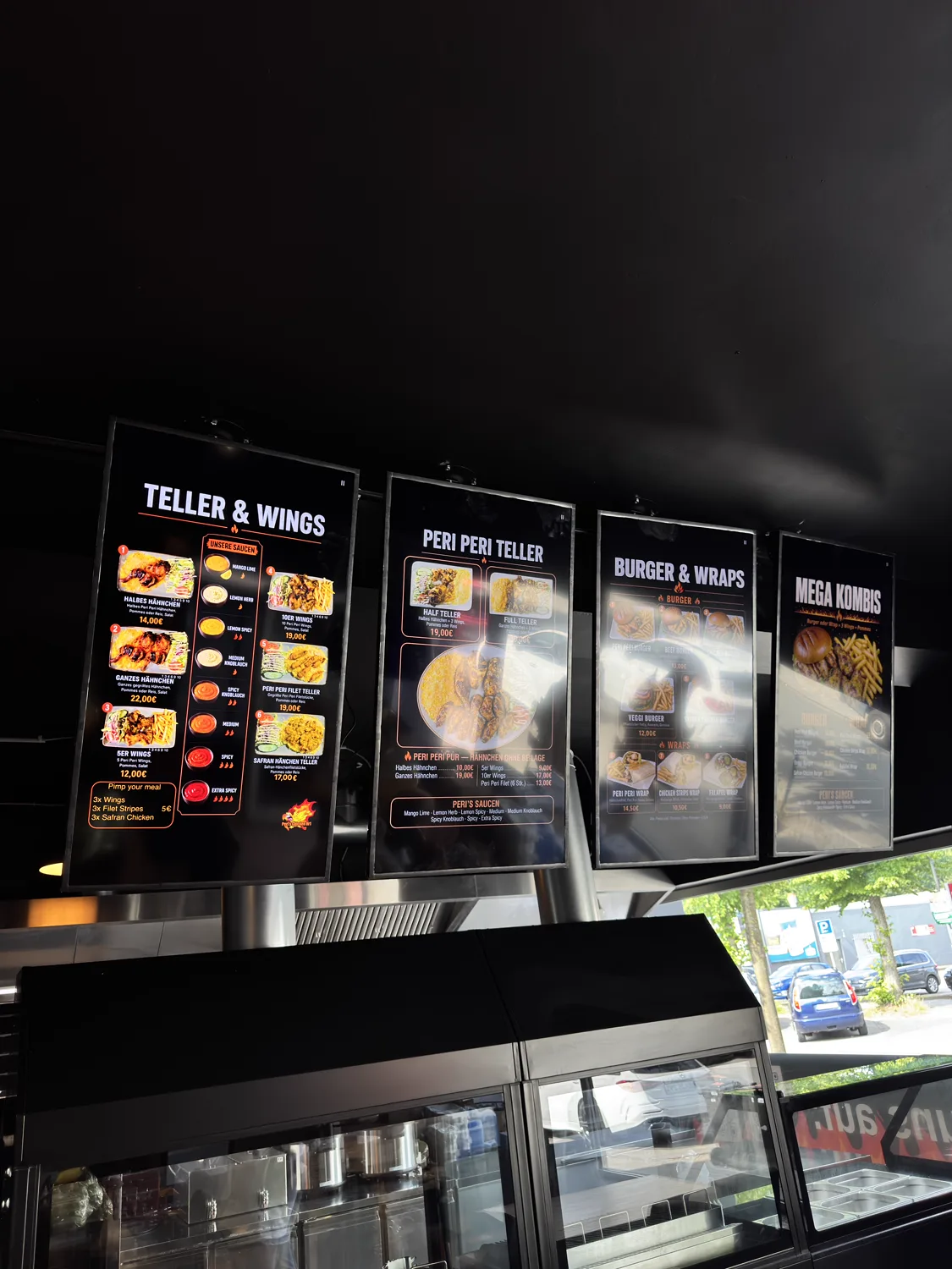Digitale Menü-Monitore an der Wand bei Peris Chicken
